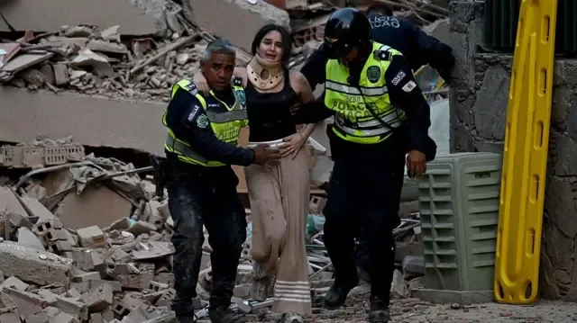 Policías socorren a una mujer entre los escombros de un edificio derrumbado en Caracas.