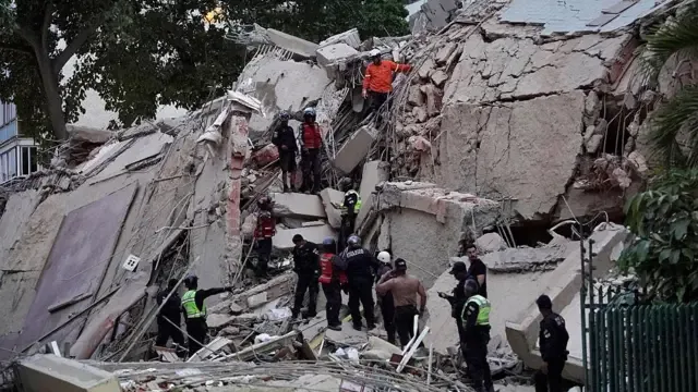 Equipos de rescate buscan víctimas entre los escombros de un edificio colapsado en Caracas tras los terremotos del 24 de junio