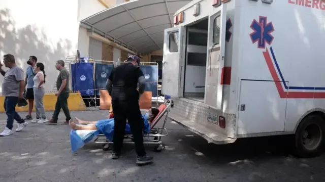 Entrada del Hospital José María Vargas. Se ve a un camillero subiendo a una herida a una ambulancia.
