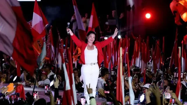 Keiko Fujimori saluda a simpatizantes en un acto de Perú con varias banderas del país en junio de 2026.