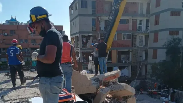 Fotografía de un rescatista y otros hombres al fondo cedida por Franco desde el lugar de la devastación en La Guaira.